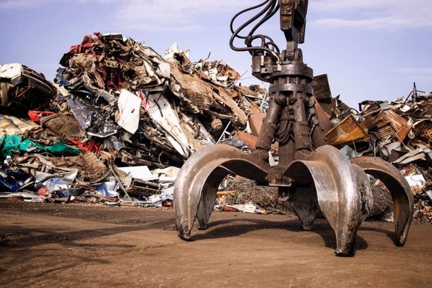 metal-junk-yard-with-hydraulic-lifting-machine-with-claw-attachment-scrap-metal-recycling_308072-1470